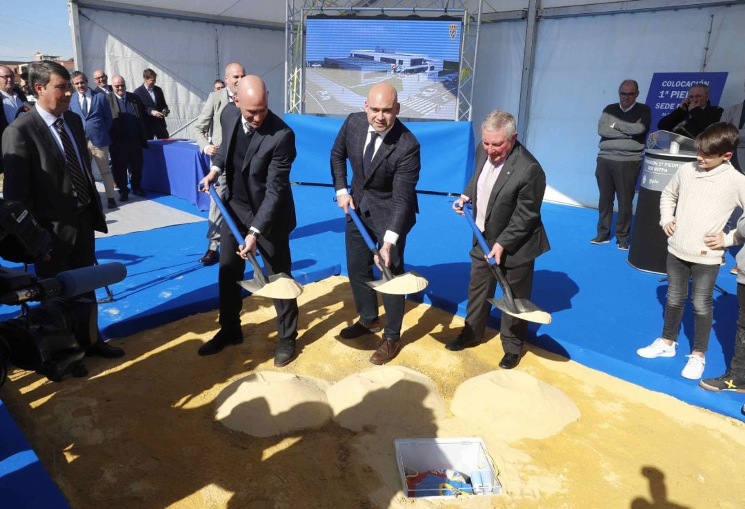 El presidente de la Real Federación Española de Fútbol, Luis Rubiales (i), el presidente de la Federación Asturiana, Maximino Martínez (d), y el concejal de Deportes, Jesús Martínez Salvador (c) durante el acto de colocación de la primera piedra de la nueva sede de la Federación Asturiana de Fútbol. 