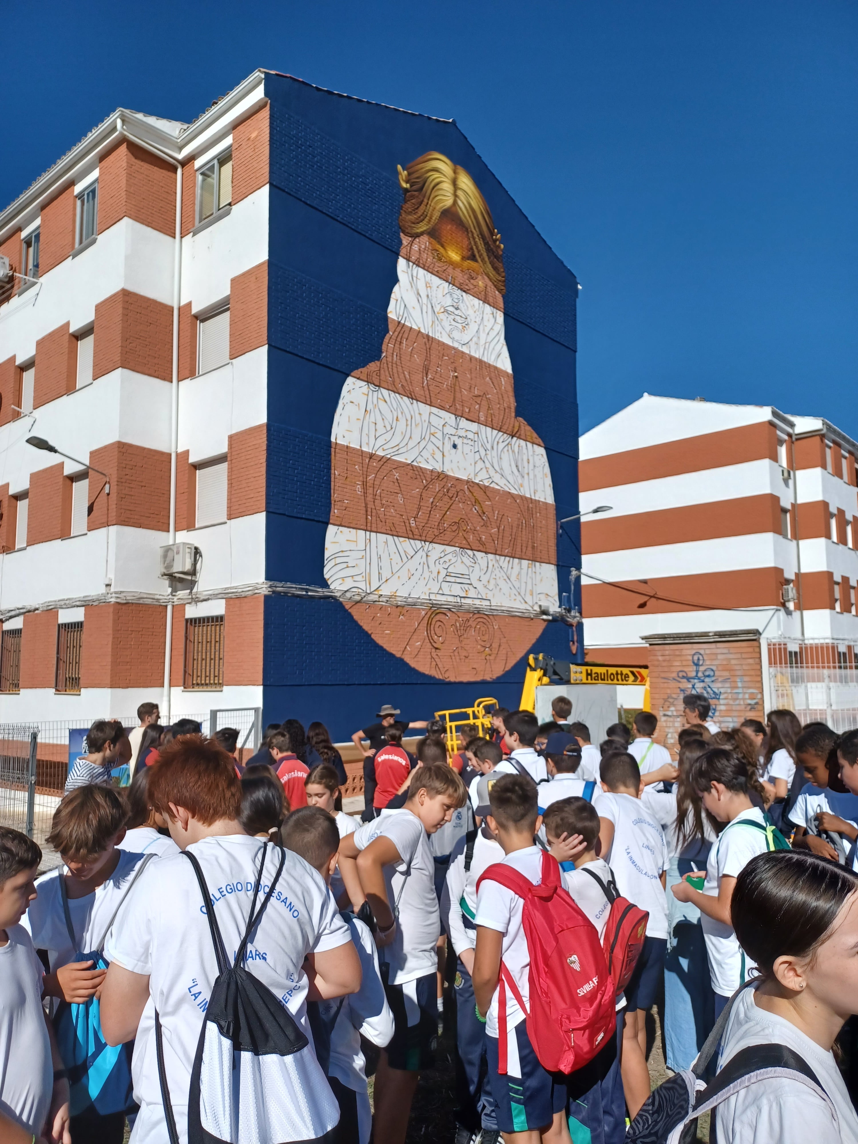 Moxaico recibe la visita de estudiantes durante la realización de su mural.