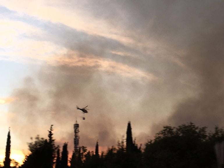 Un helicópetero trabaja en las labores de extinción del fuego en la frontera de Caya