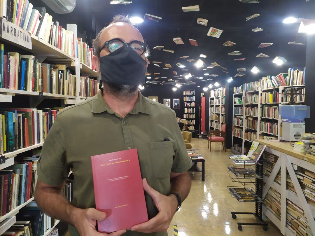 José Daniel Espejo posa con un ejemplar de &quot;Los lagos de Norteamérica&quot; en Libros Traperos, la librería que dirige