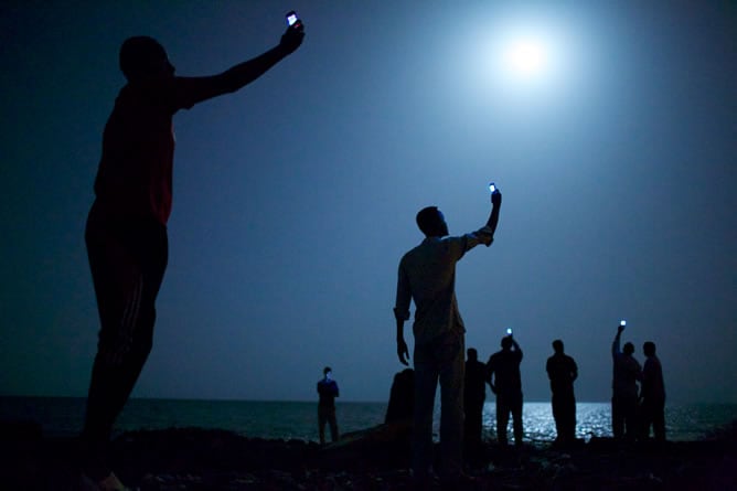 "Señal", un grupo de inmigrantes africanos en una playa de la República de Yibuti levantan sus teléfonos móviles para capturar una red telefónica de la vecina Somalia, de donde proceden, para hablar con sus familias.