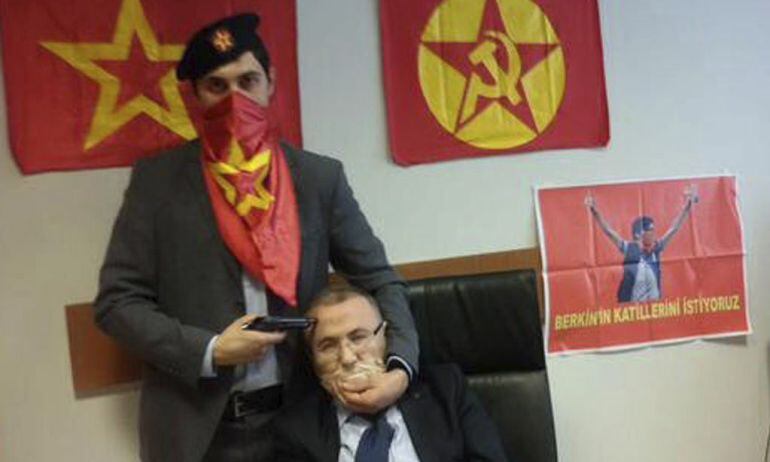 Fotografía publicada en Twitter por el partido ilegalizado DHKP-C que muestra a una persona no identificada mientras apunta con un arma a la cabeza de un fiscal, identificado por el diario Hürriyet como Mehmet Selim Kiraz, delante de una bandera del parti