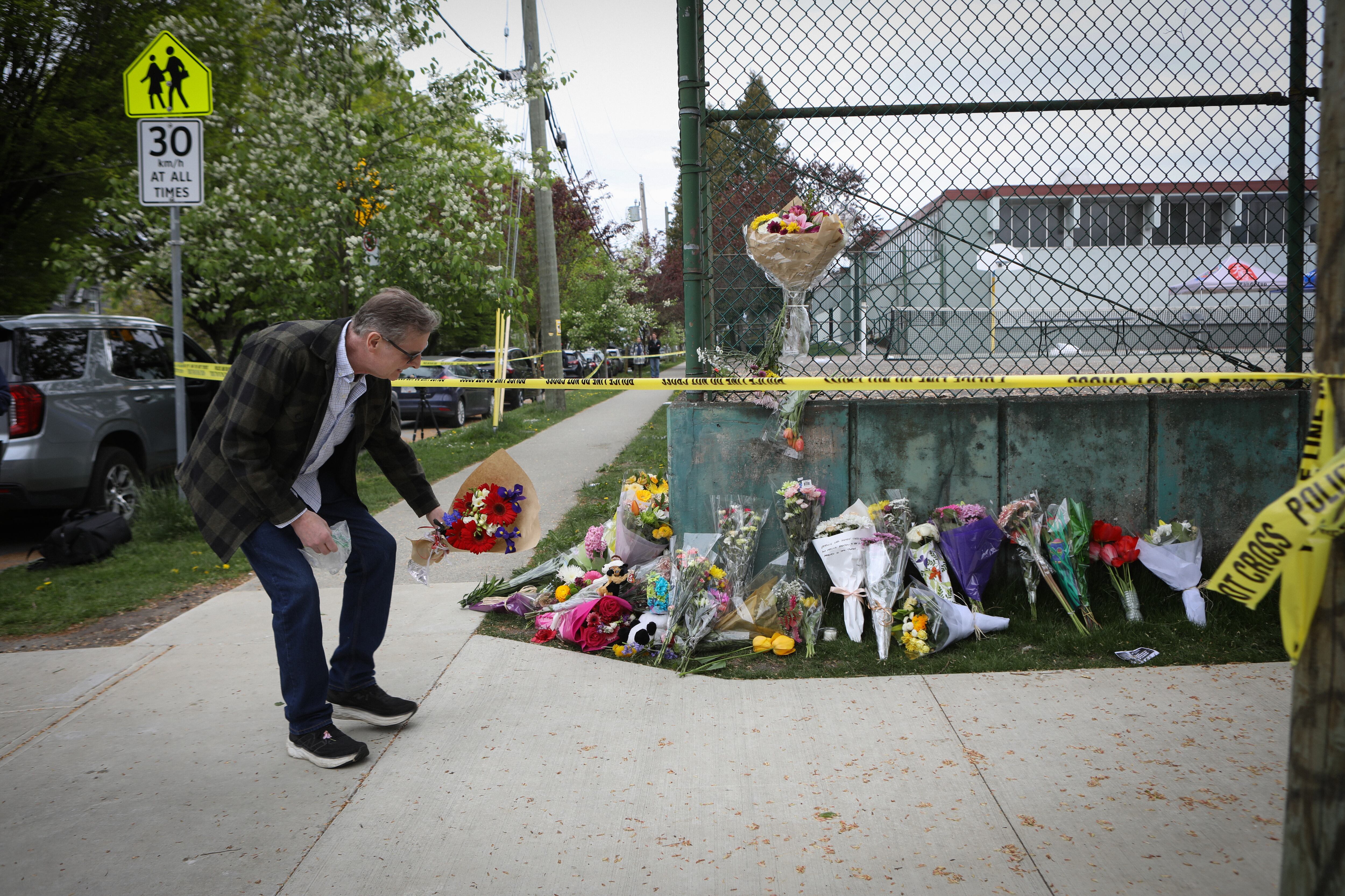 Un hombre deja flores para recordar a las víctimas del atropello múltiple durante un festival de música en Vancouver.
