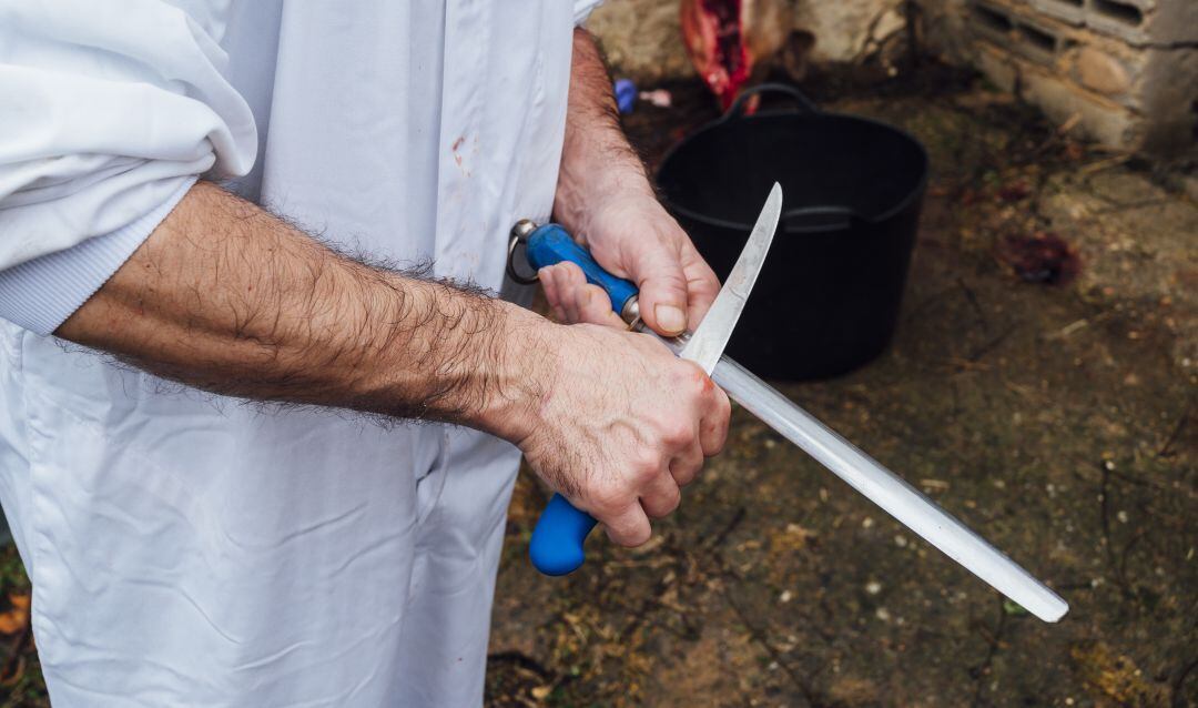 Carnicero afilando uno de sus cuchillos