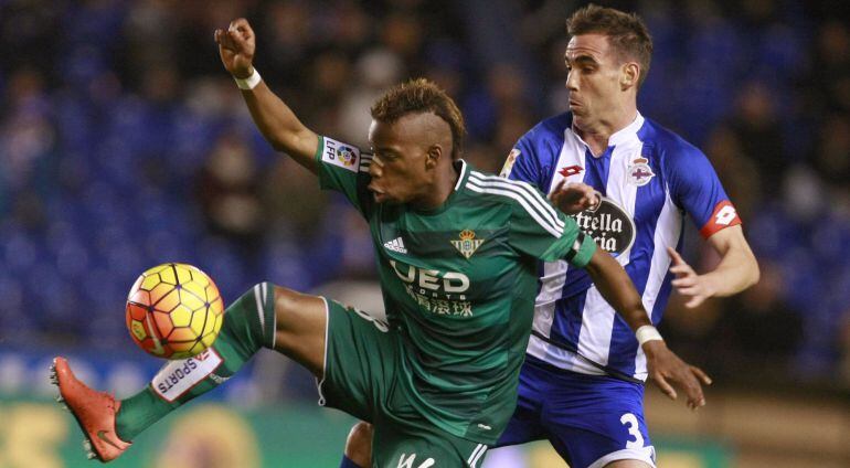 El centrocampista belga del Betis, Charly Musonda , intenta controlar el balón ante el defensa del Deportivo, Fernando Navarro, durante el encuentro correspondiente a la jornada 24 de primera división.