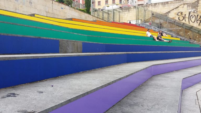 Las gradas de la plaza de Unzaga han sido decoradas con los colores de la bandera arco iris