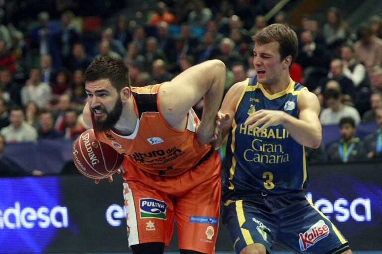 El pívot montenegrino del Valencia Basket Bojan Dubljevic (i) intenta escaparse del canadiense Kevin Pangos, del Herbalife Gran Canaria, durante el partido de la segundo eliminatoria de los cuartos de final de la Copa del Rey de baloncesto que se disputa 