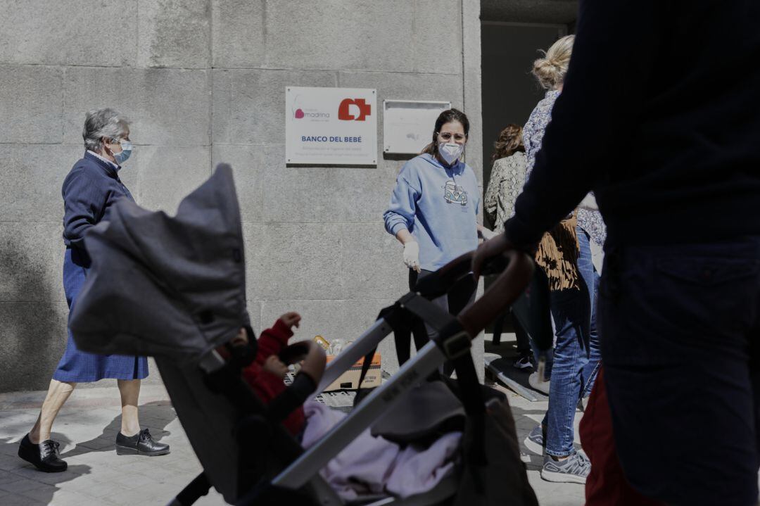 Mujeres esperan en las inmediaciones de la Parroquia Santa María Micaela y San Enrique para recibir ayuda de la Fundación Madrina