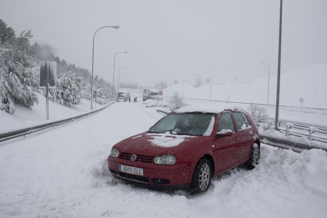 Un vehículo atrapado por la nieve en una de las carreteras de acceso al distrito de Hortaleza, en Madrid (España) a 9 de enero de 2021. El Ayuntamiento de Madrid pide a los propietarios de los coches abandonados en la M-30 que no acudan a recogerlos,