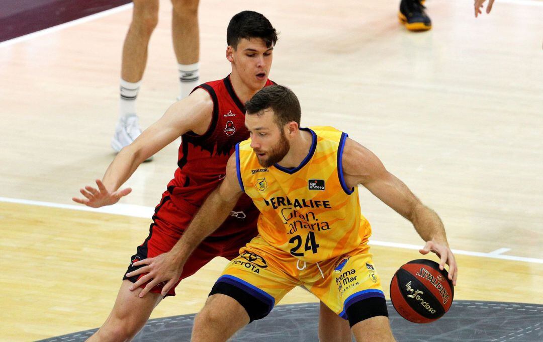 El pívot estadounidense del Herbalife Gran Canaria, Matt Costello, es defendido por el ala pívot del Casademont Zaragoza, Jaime Pradilla, durante el primer partido de la cuarta jornada del grupo B de la fase final de la Liga Endesa que disputan en el pabellón de la Fuente de San Luis de Valéncia. 