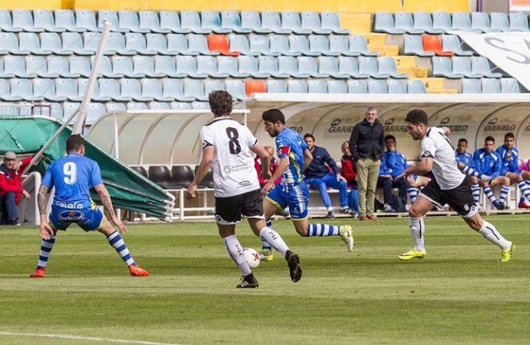 Ruba avanza con el balón ante la mirada de Rubiato (9) y flanqueado por dos jugadores del Salmantino. Al fondo en el banquillo, el entrenador blanquiazul, Javier Álvarez de los Mozos, de pie.