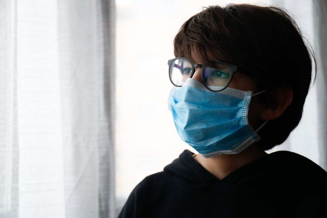 Un niño con mascarilla en su casa.