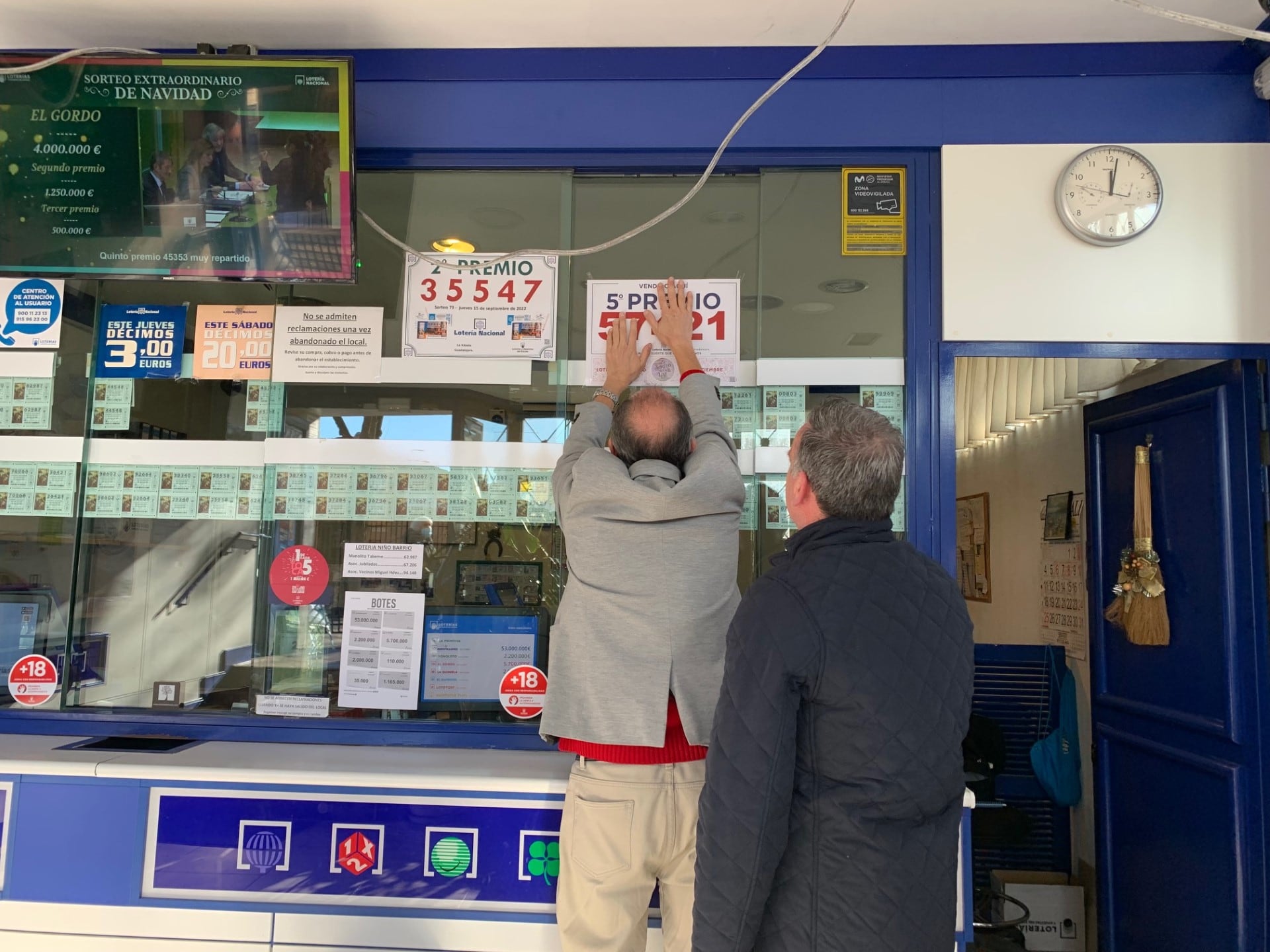 Colocando el cartel con el quinto premio