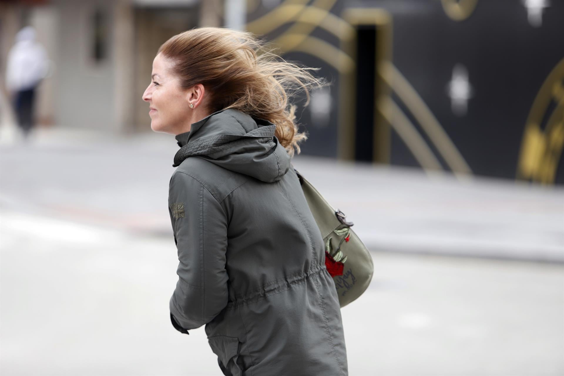 Imagen de archivo. Una mujer intenta andar por la calle en un temporal marcado por las fuertes rachas de viento. - Álex Zea - Europa Press