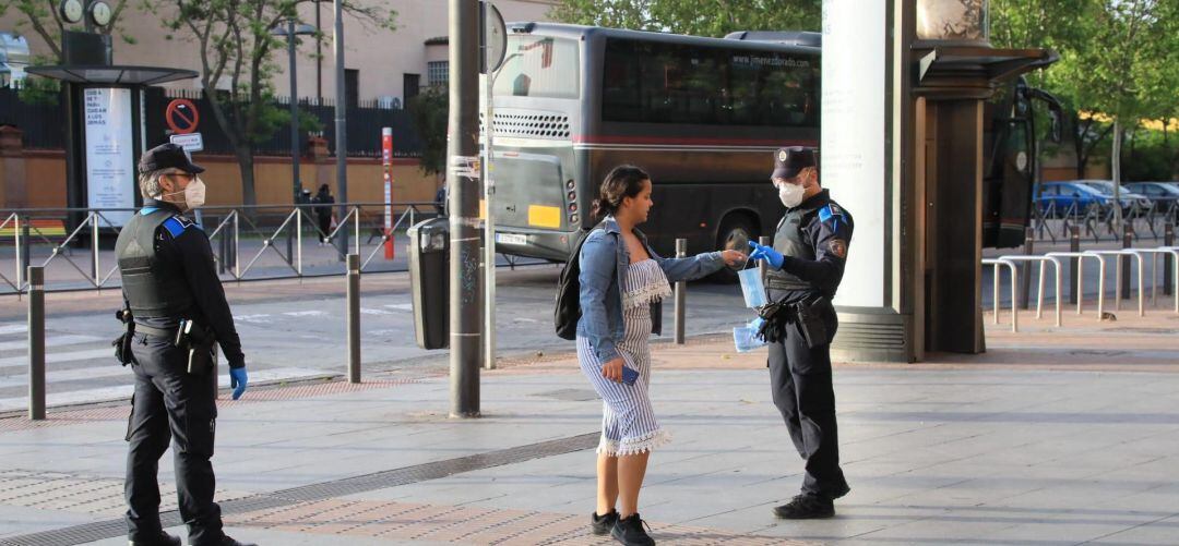 Un agente de Policía local de Getafe entrega una mascarilla a una ciudadana