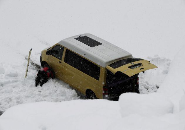 FOTOGALERÍA | Una persona intenta sacar su furgoneta de la nieve en La Contienda, en Larra-Belagoa.