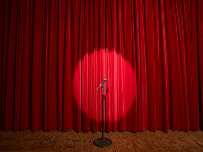 Imagen de un escenario teatral con un micrófono