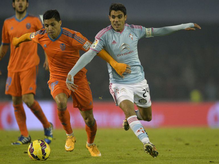 Valencia&#039;s Argentinian midfielder Enzo Perez (L) vies with Celta&#039;s Argentinian midfielder Augusto Fernandez during the Spanish league football match RC Celta de Vigo vs Valencia CF at the Balaidos stadium in Vigo on January 10, 2015.   AFP PHOTO/ MIGUEL RIOPA