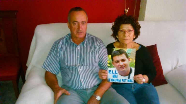 Fernando i Conxita a casa seva mostrant una foto del seu fill.