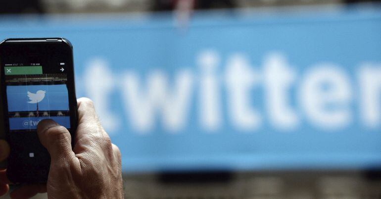 Un hombre fotografía el logotipo de Twitter con su teléfono móvil