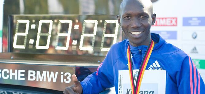 El ganador de la prueba en Berlín posa con su tiempo, el nuevo récord del mundo