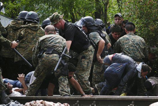 Migrants fall as they make their way through police to cross Greece&#039;s border into Macedonia near Gevgelija, Macedonia, August 22, 2015. Thousands of migrants stormed across Macedonia&#039;s border on Saturday, overwhelming security forces who threw stun grenad