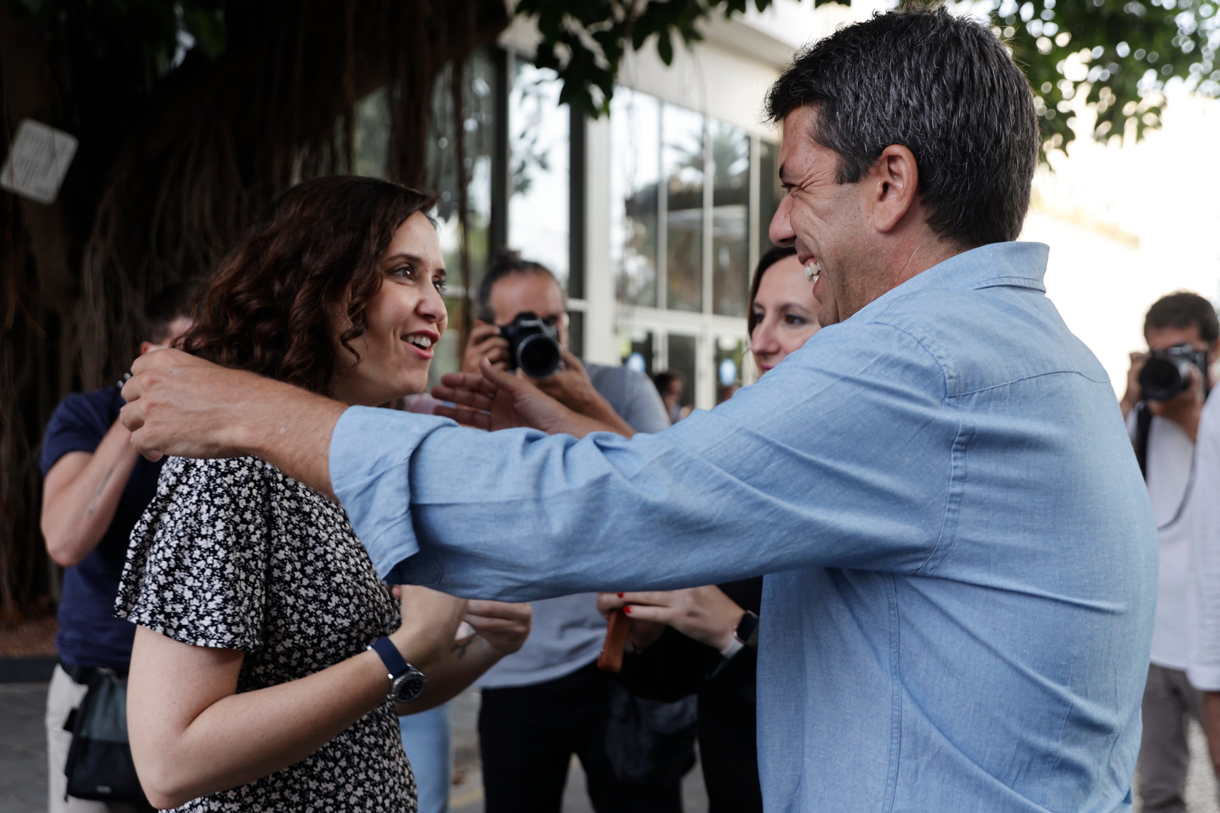 El presidentde la Generalitat, Carlos Mazón (d), saluda a la presidenta de la Comunidad de Madrid, Isabel Díaz Ayuso  a su llegada al encuentro que con los militares en el mes de julio de 2023.