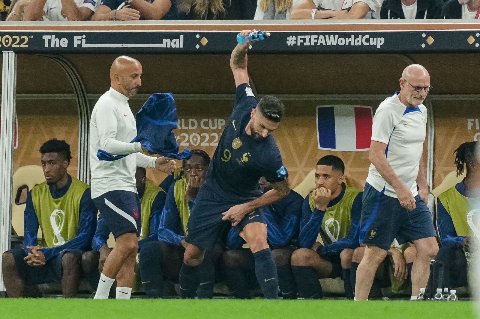 Giroud lanza al suelo una botella.