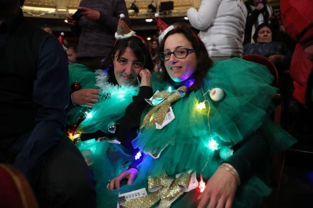 Dos chicas disfrazadas de árbol de Navidad.