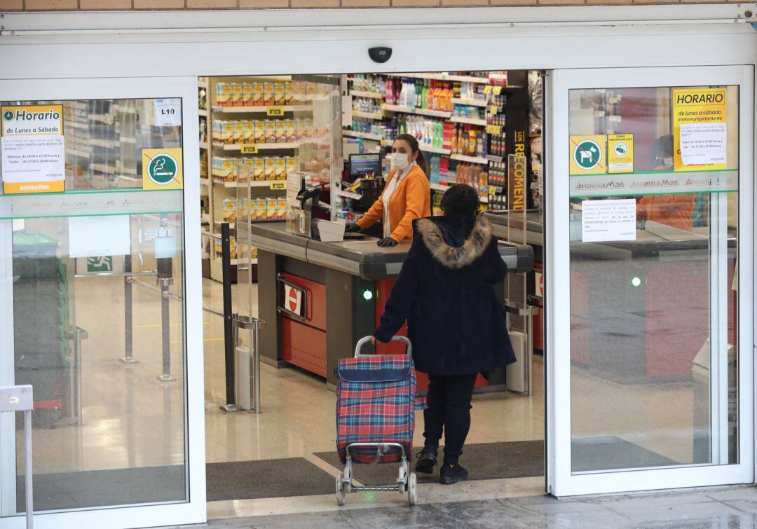 Una mujer entra a hacer la compra a un supermercado en plena crisis sanitaria por coronavirus 