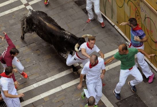 FOTOGALERÍA | Uno de los toros de la ganadería madrileña de Victoriano del Río Cortes golpea a un mozo en la calle Estafeta.