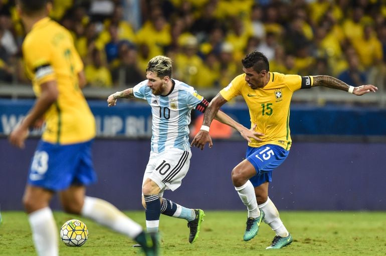 Messi y Paulinho se disputan el balón durante un partido de las selecciones