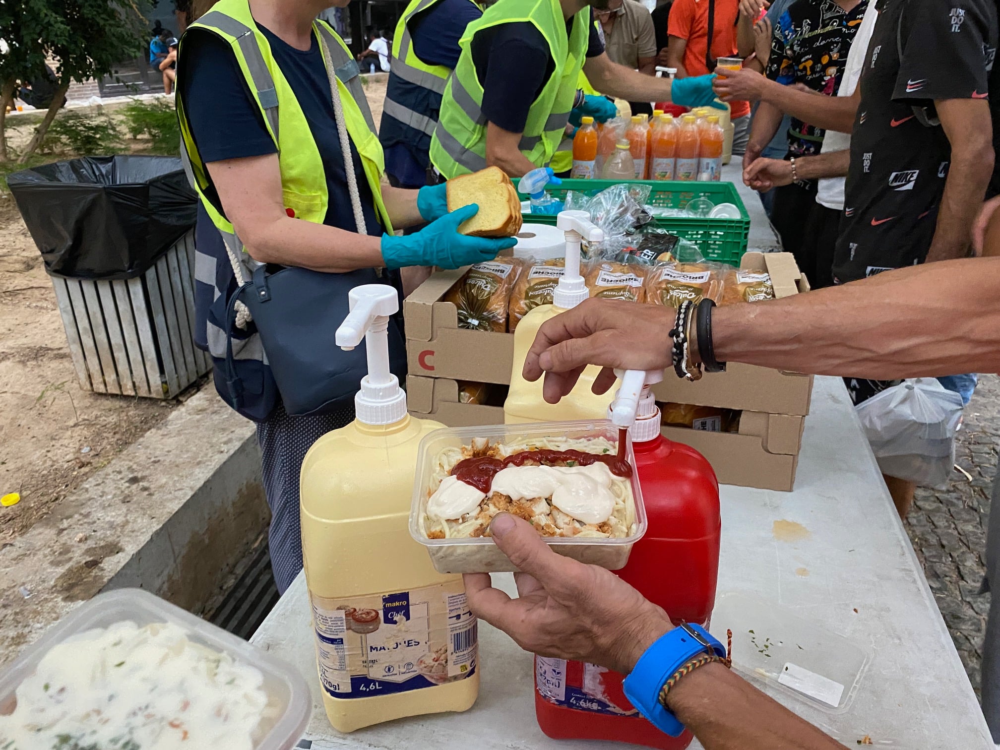 Una de las personas atendidas por la entidad pone salsas en su comida