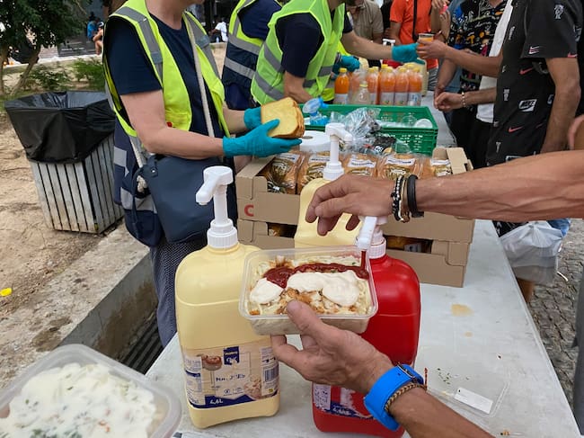 Una de las personas atendidas por la entidad pone salsas en su comida