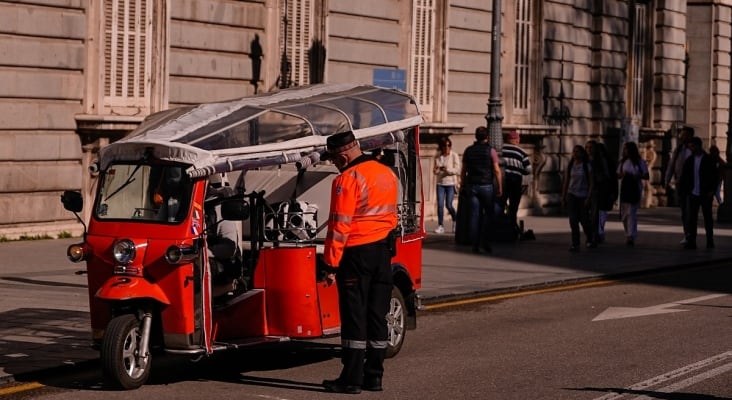 Un agente de Movilidad inspecciona un Tuk Tuk junto al Palacio Real de Madrid