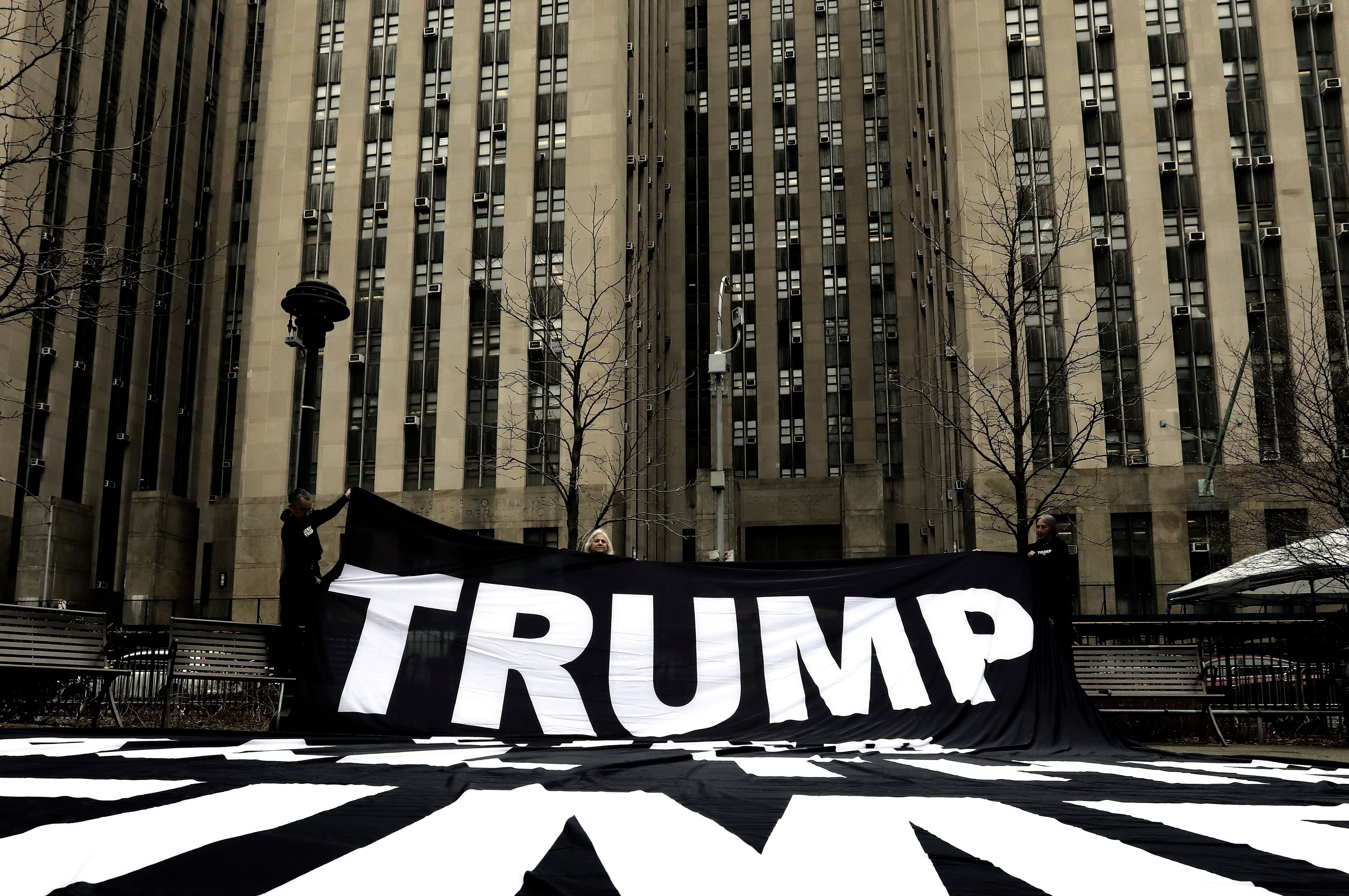 Manifestantes despliegan una pancarta de apoyo a Trump frente al Tribunal Penal de Nueva York