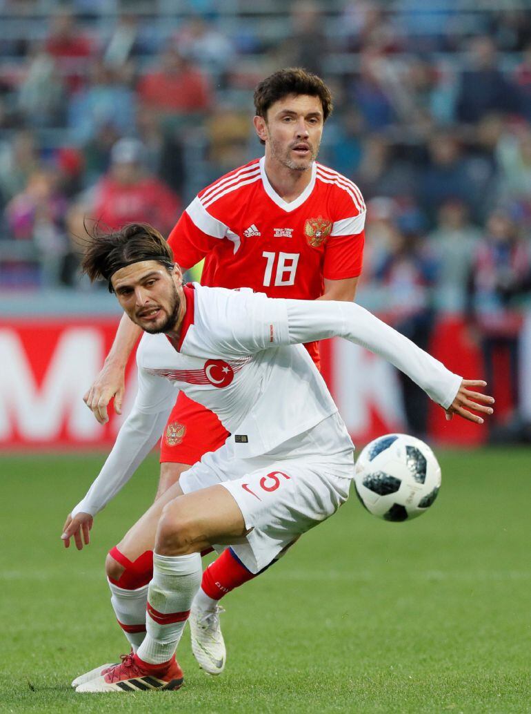 El jugador turco Okay Yokuslu (frente) disputa el balón con el ruso Yusuf Yazici durante un partido amistoso disputado en el estadio VTB Arena en Moscú