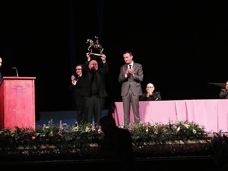 El pregonero recibe la escultura de Cantó de manos del alcalde y del presidnente de la Venida