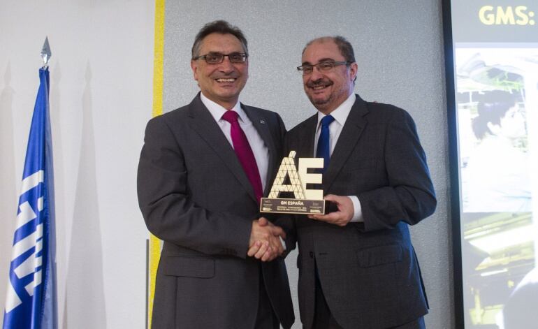 El director general de General Motors España, Antonio Cobo (i), recibe el Sello de Oro de manos del presidente aragonés, Javier Lambán (d), durante la I Jornada Puertas Abiertas Sello de Oro Aragón Empresa.