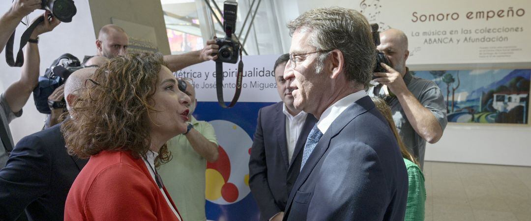 La ministra de Hacienda en funciones, María Jesús Montero y  el presidente de la Xunta de Galicia, Alberto Núñez Feijóo, se saludan a su llegada a la presentación del Anuario 2019 en la sede de Afundación