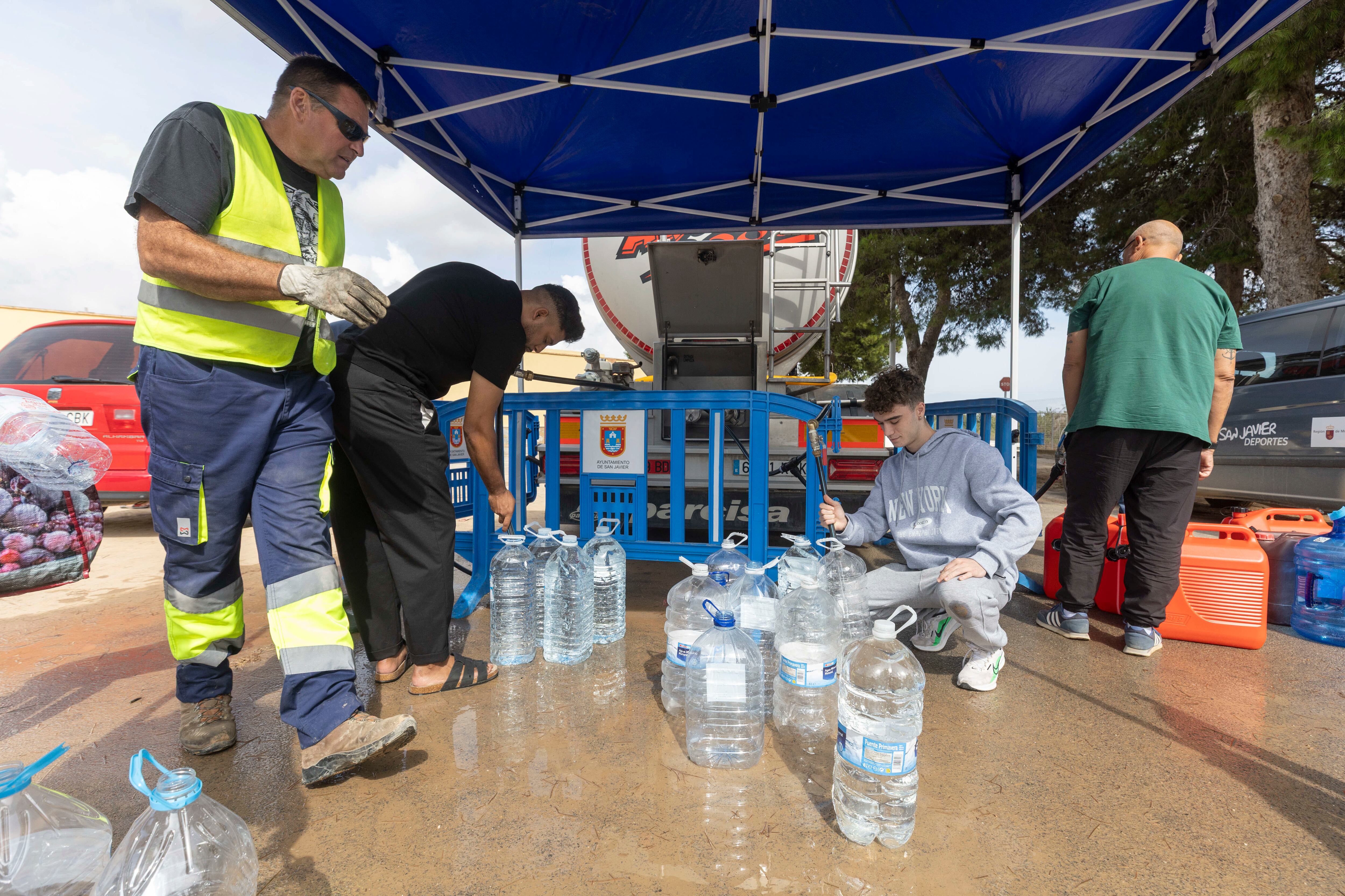 SAN JAVIER, (MURCIA), 16/10/2025.- Vecinos de San Javier, Murcia, llenan garrafas de agua potable de un camión cisterna. EFE/Marcial Guillén