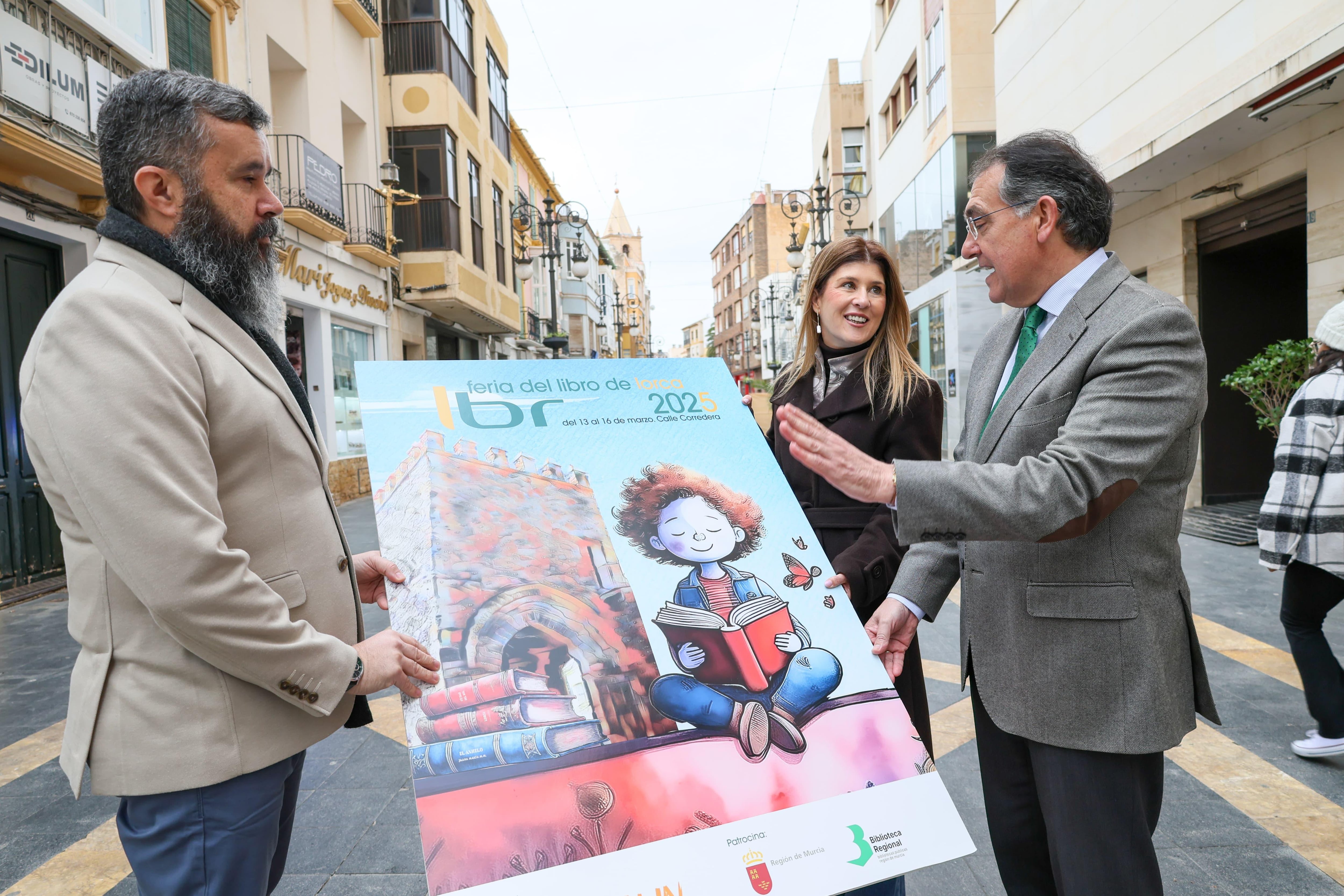 Jesús Boluda del Toro, director de la Feria del Libro, Rosa María Medina, edil de Educación y Santiago Parra, concejal de Cultura con el cartel de la Feria del Libro de Lorca