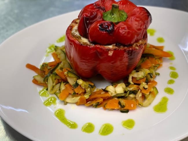 Pimiento relleno de perdiz sobre una cama de verduritas