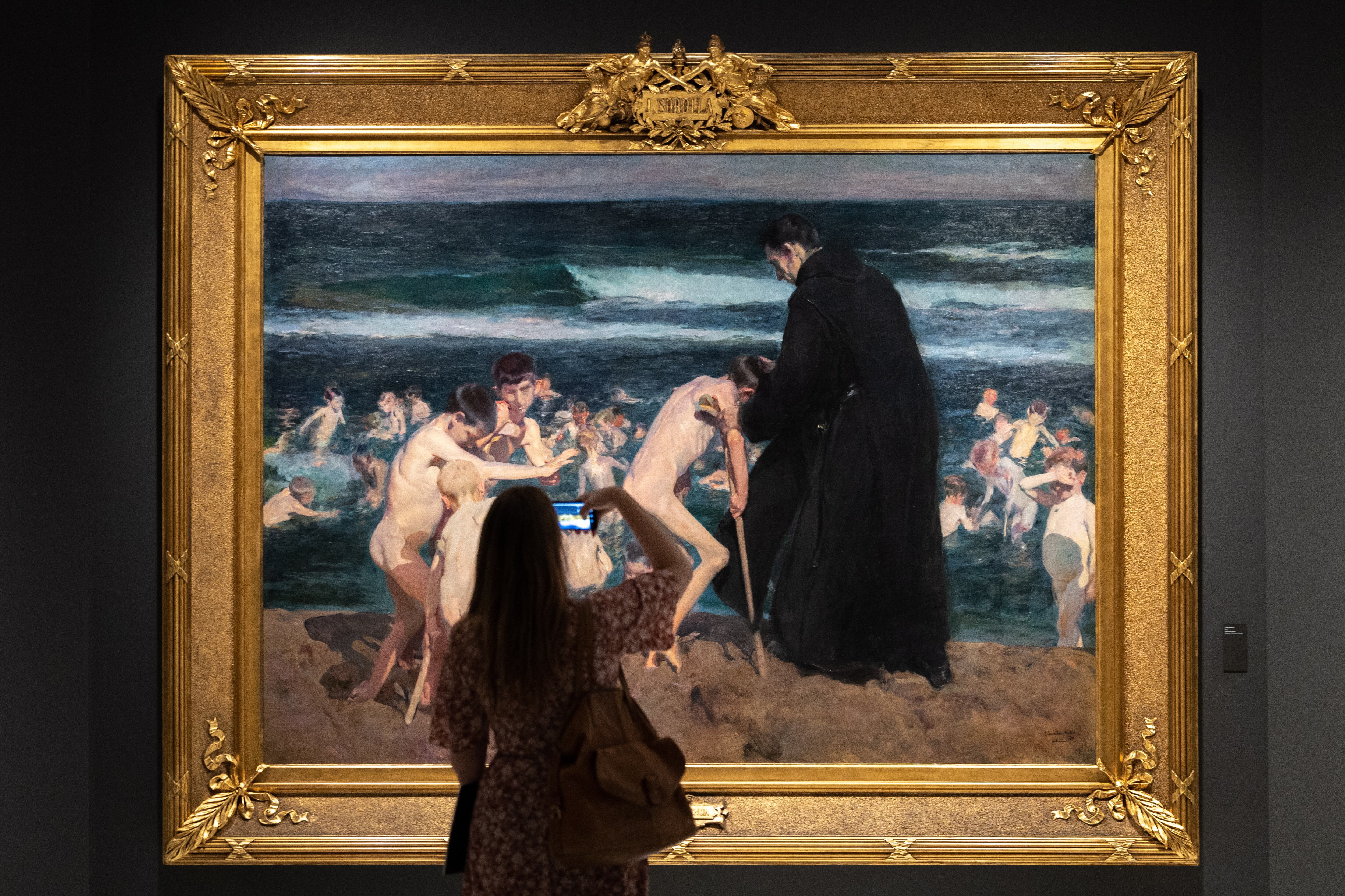 Una persona contempla una obra de una exposición de Sorolla.