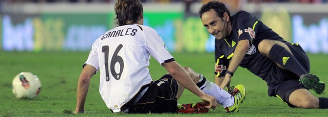 El árbitro Iturralde González se levanta tras resbalarse y derribar al centrocampista del Valencia CF, Sergio Canales, durante el partido frente al Granada CF correspondiente a la séptima jornada de la Liga en Primera División disputado en el estadio de M