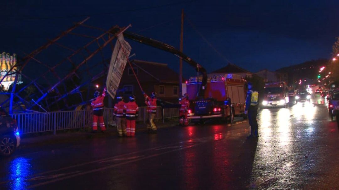 Bomberos retiran una valla que derribó el temporal