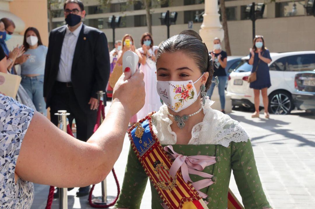 La fallera mayor infantil de València, Carla García, se toma la temperatura antes de entrar a la entrega de los premios falleros