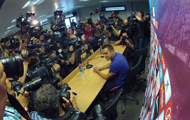 Xavi, rodeado de fotógrafos antes de que comience la rueda de prensa en la que ha anunciado su adiós al Barça