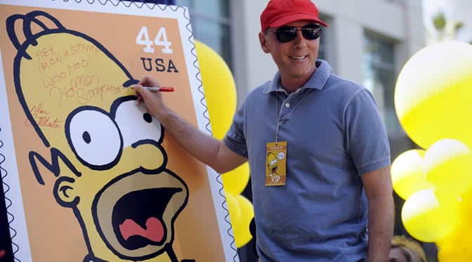 Dan Castellaneta, la voz original de Homer Simpson, firma un poster con la imagen que aparece en los nuevos sellos