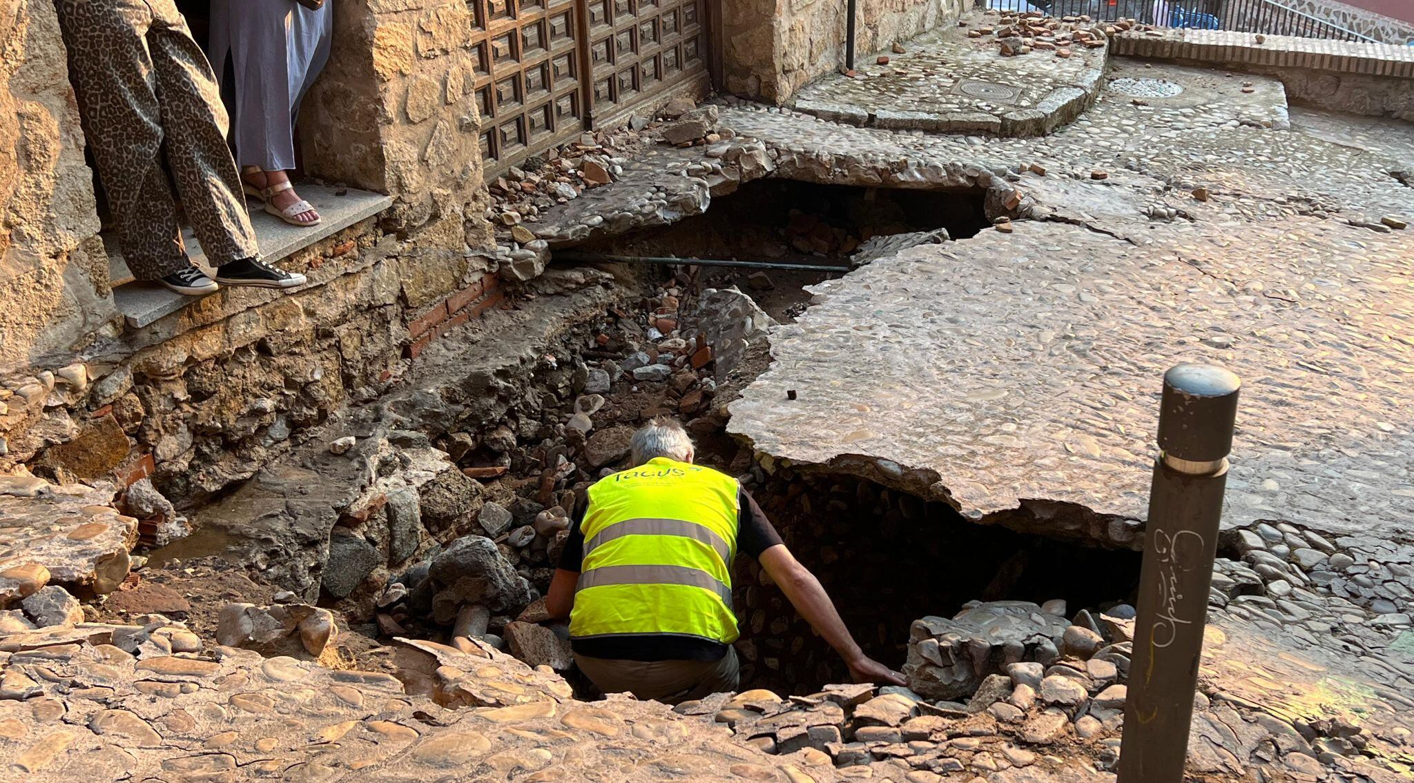 Un operario de Tagus, la empresa concesionaria del agua en Toledo, en el interior del socavón que ha dejado la rotura de una tubería de la red general